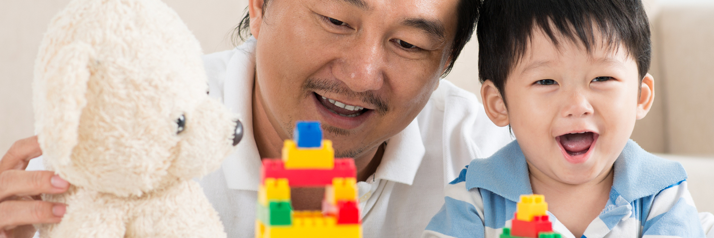 Man and child playing with building blocks