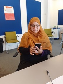 An image of a women in a classroom using her smartphone