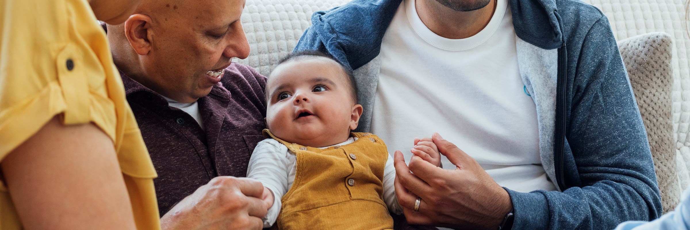 A group of adults smiling at a child