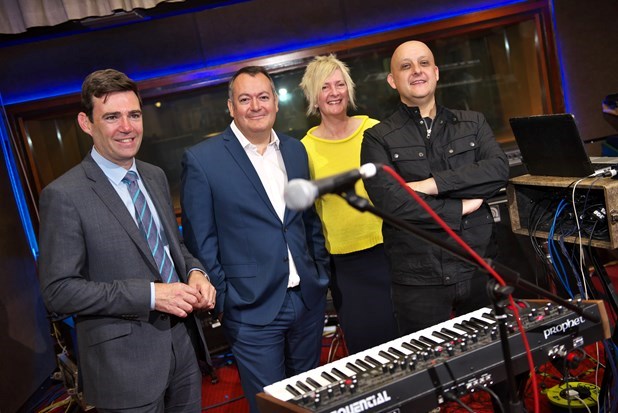 Mayor of Greater Manchester Andy Burnham with three other people stood in a music recording studio