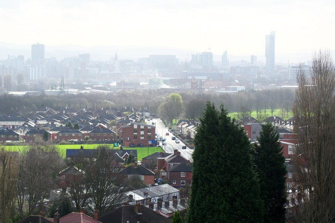 A view of houses with Manchester city in the background