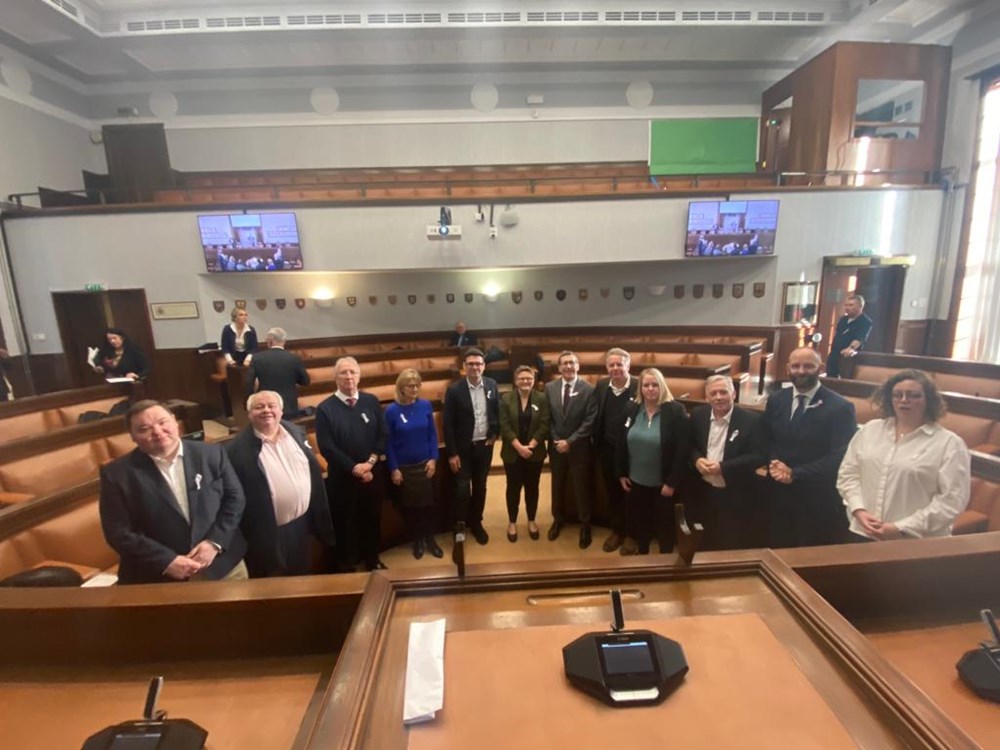 The 10 leaders of Greater Manchester wearing White Ribbons in Salford Council Chamber.