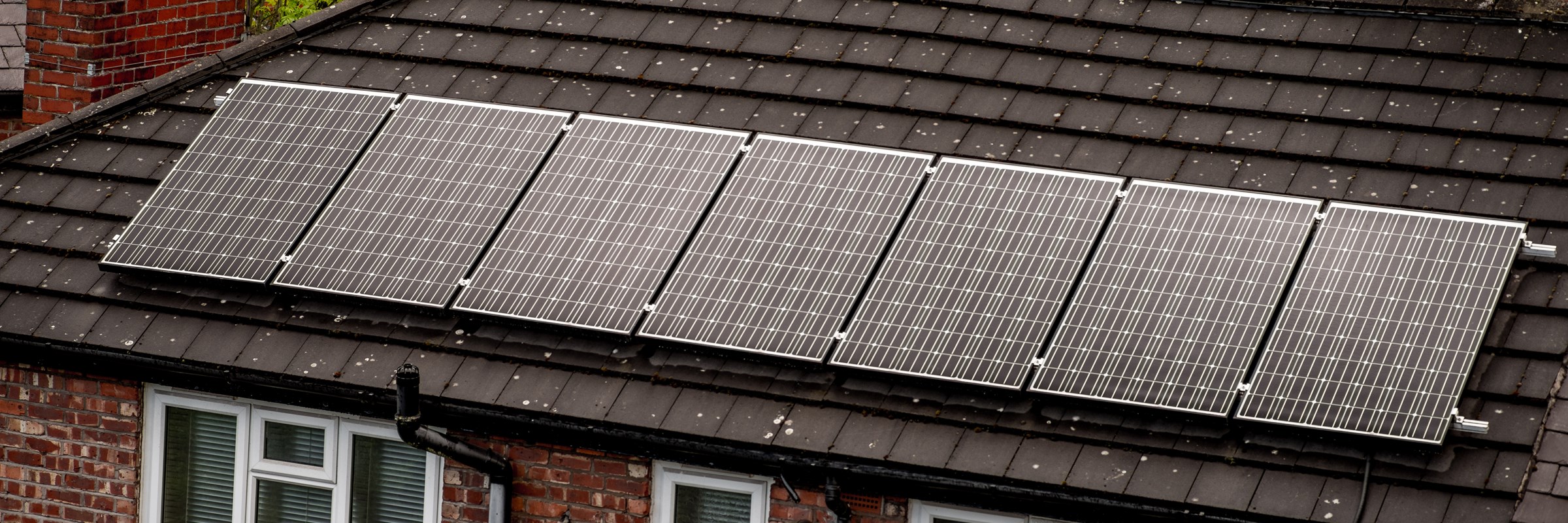Solar panels on suburban redbrick house roof