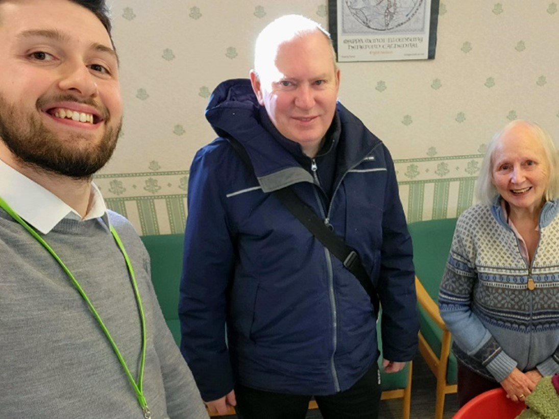 Three people stood together smiling taking a selfie