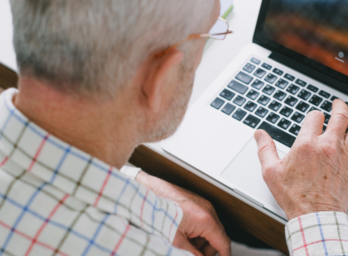 Image of person sat a at table using a laptop