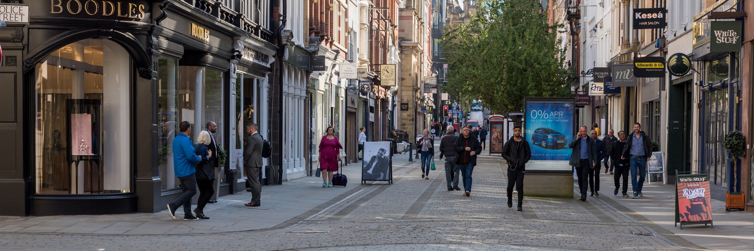 People walking down a street in Manchester City Centre