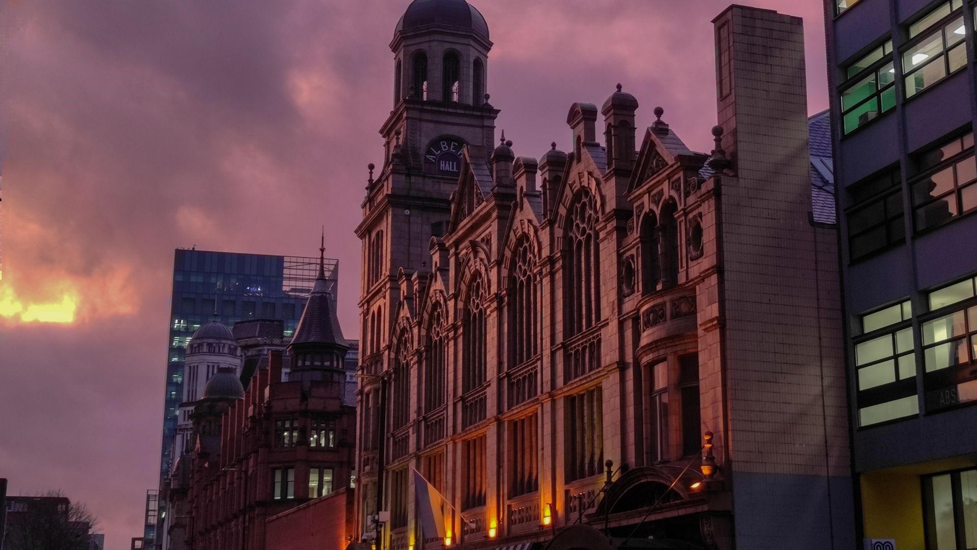 a city street at dusk with buildings and a clock tower