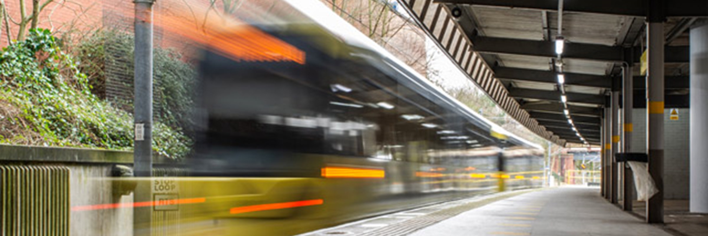 tram going past a tram station in Greater Manchester