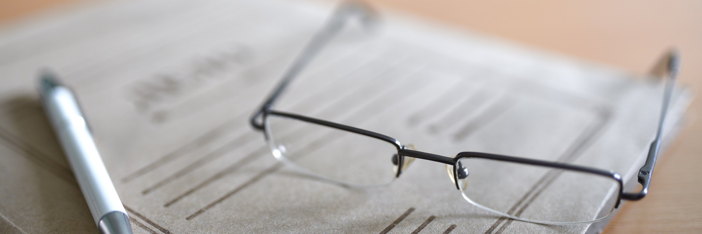 Paper folder with court documents on the table, glasses, pen