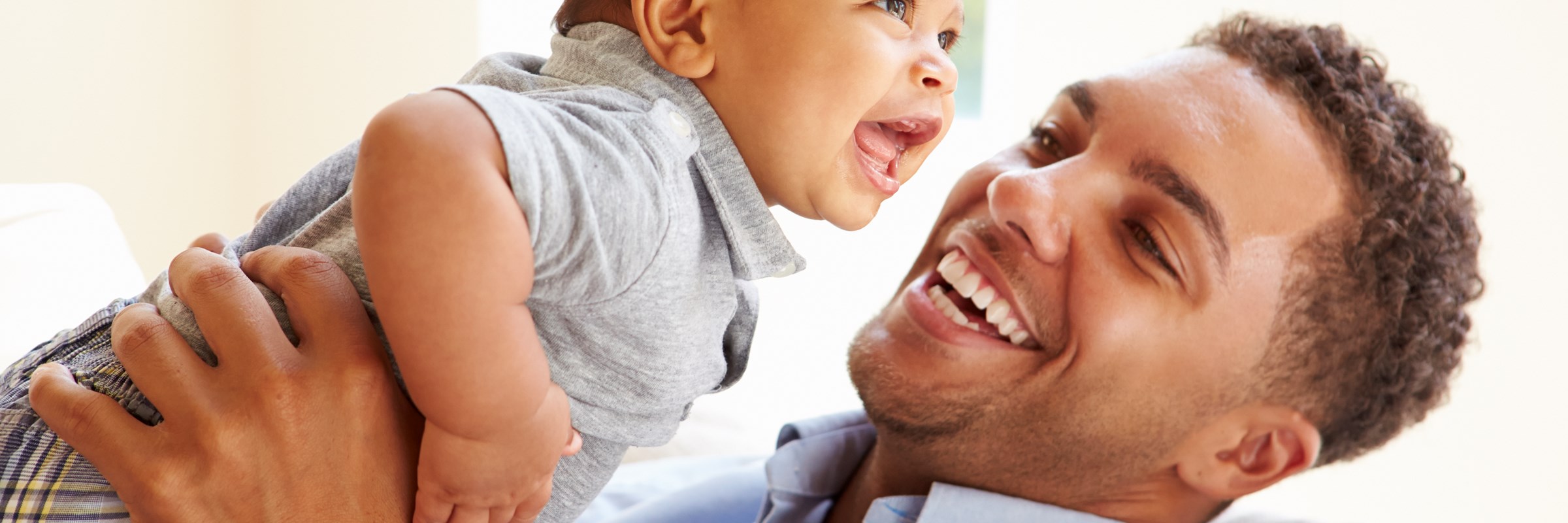 Happy man holding a baby