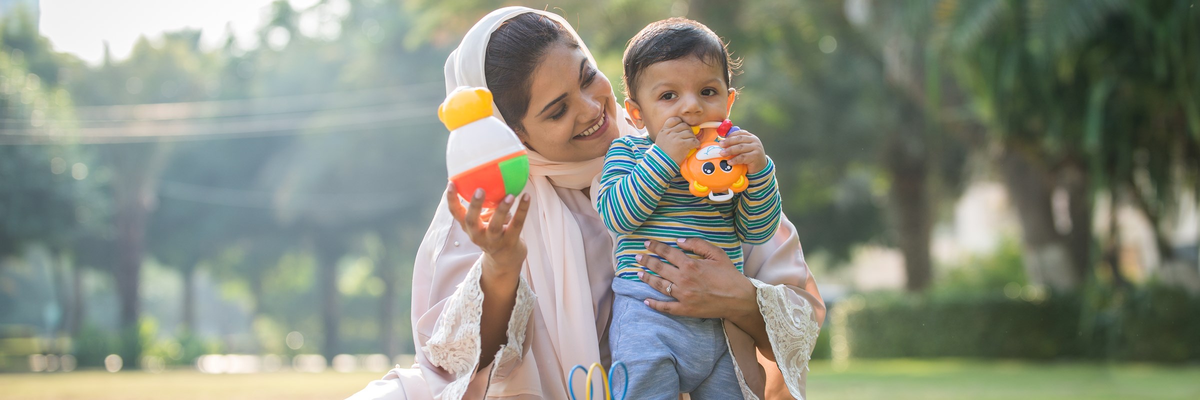 A woman holding a child while they play with toys