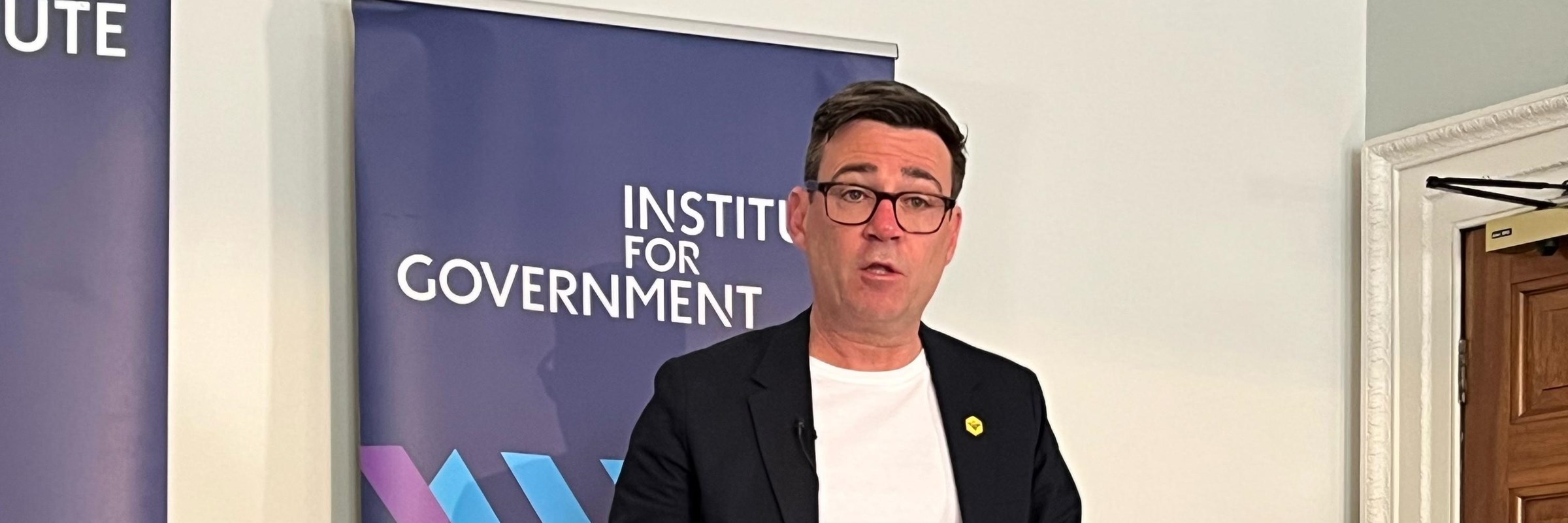 Mayor of Greater Manchester, Andy Burnham, stood at a lectern