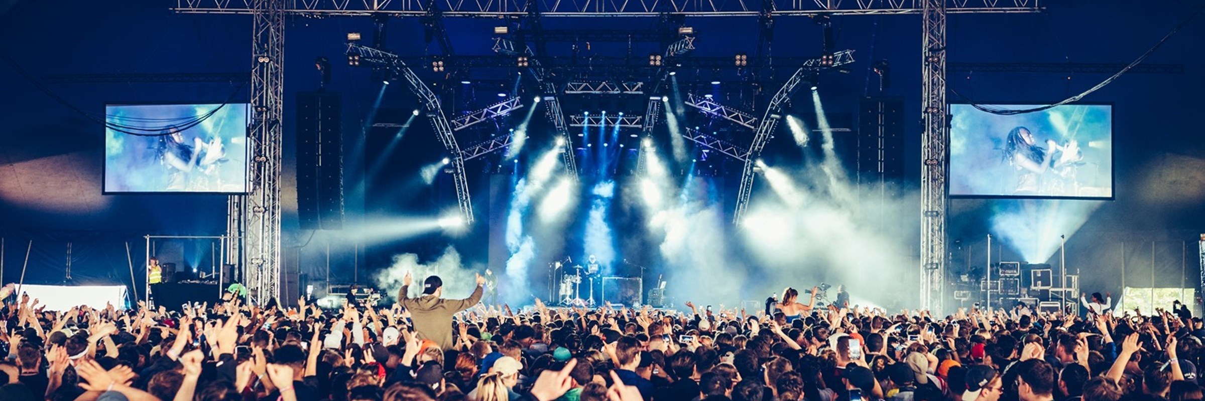 A crowd of people looking towards the stage at a concert