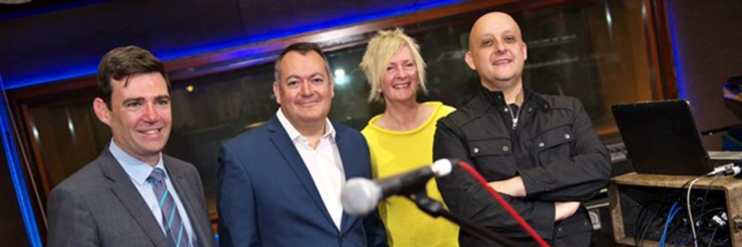 Mayor of Greater Manchester Andy Burnham with three other people stood in a music recording studio