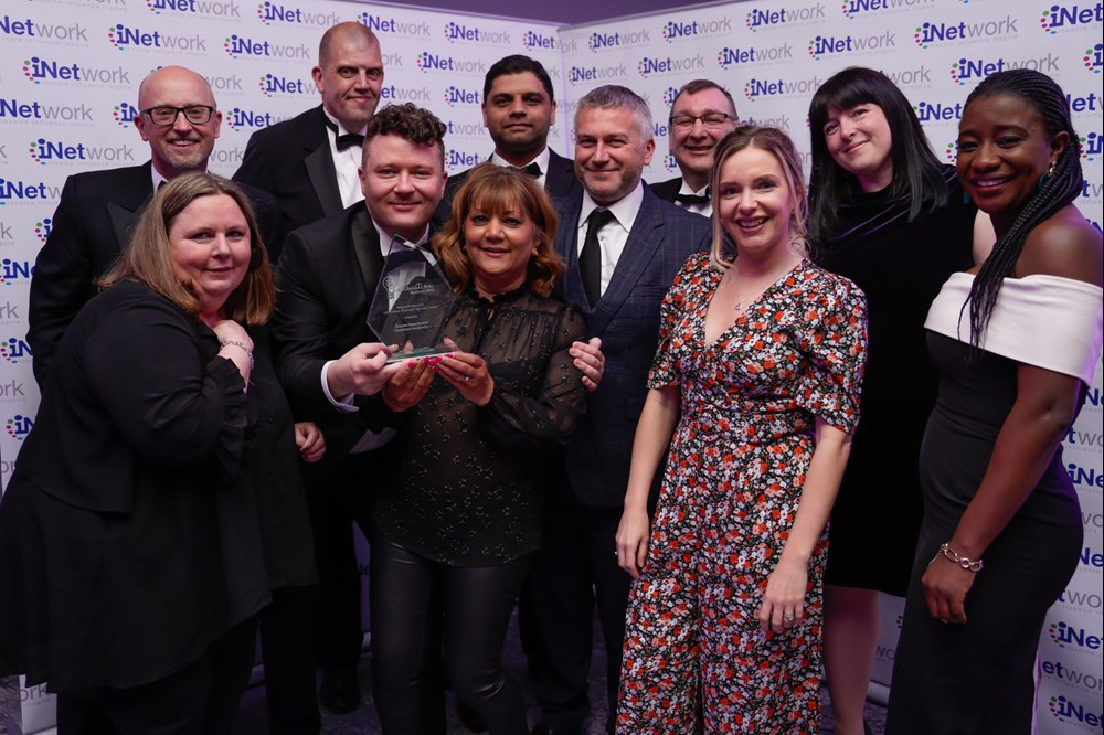 Image of people with award in front of back drop