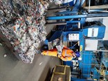 A recycling operative in hi-vis loads bales of compacted aluminium cans onto a pallet