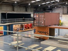 A view of the event space at the Renew Hub, with wooden benches and repurposed shipping containers