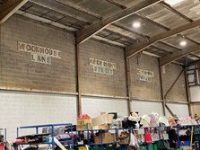 Stock sitting on racks ready to go out to the three Renew shops, with signs above each one for Woodhouse Lane, Arkwright Street and Boysnope Wharf