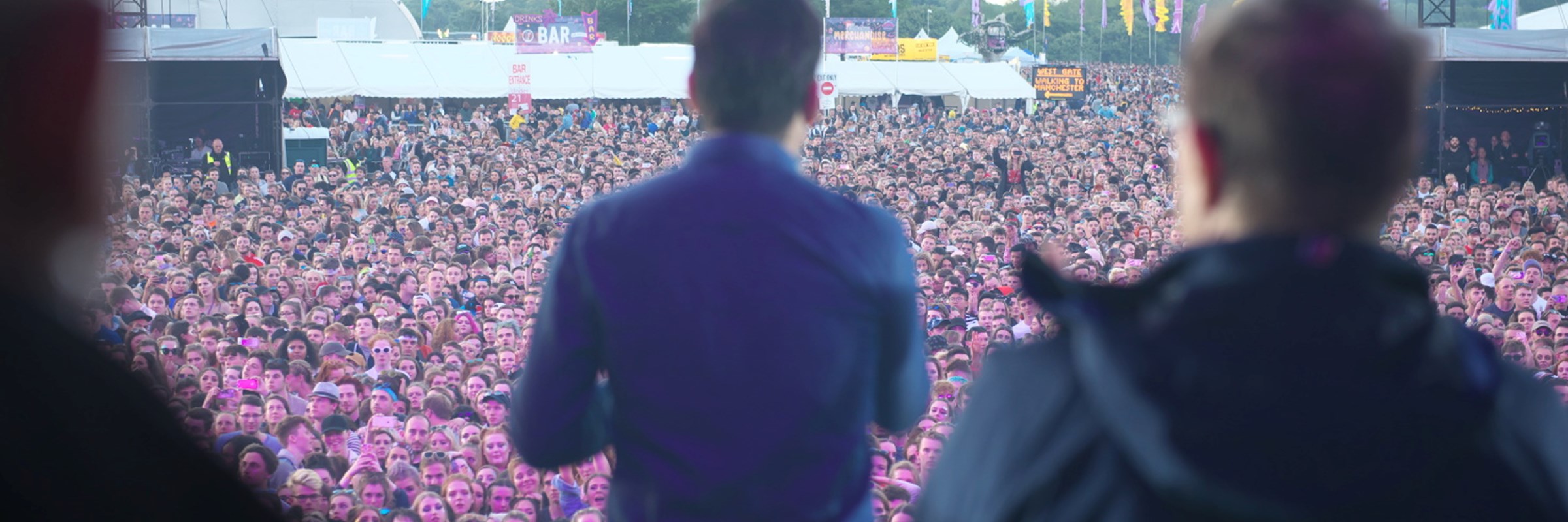 The Mayor has his back to camera - he is on a big stage facing a large crowd at a music concert