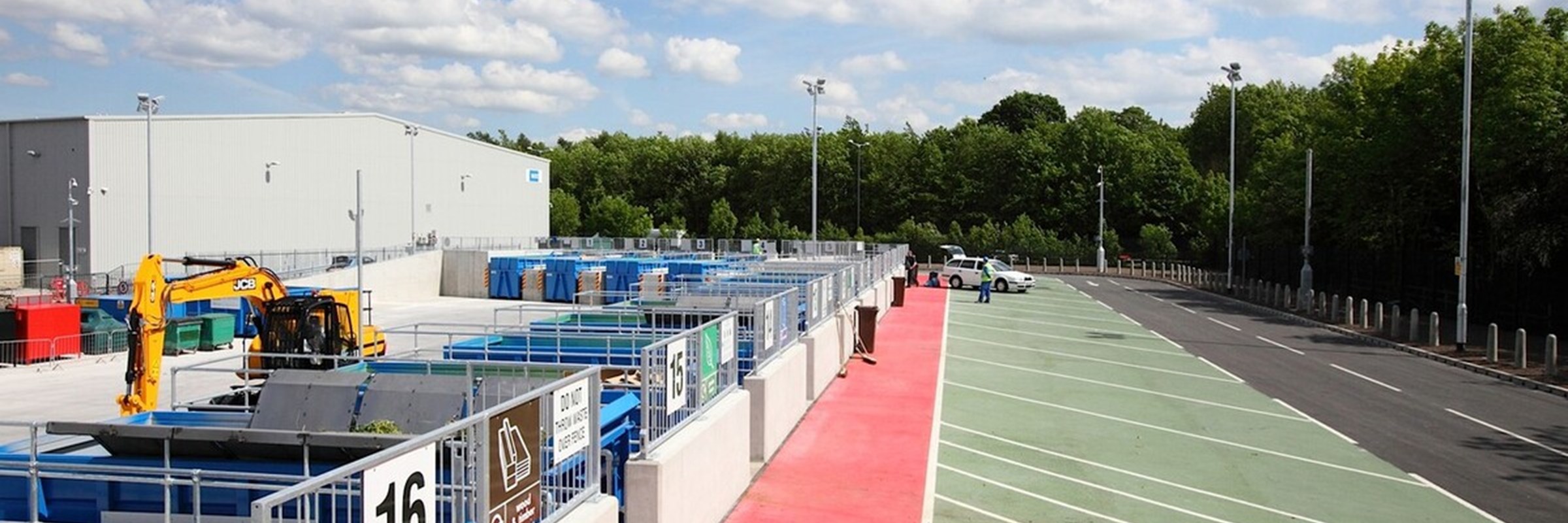 photo of Longley Lane recycling centre, a JCB can be seen moving items from containers