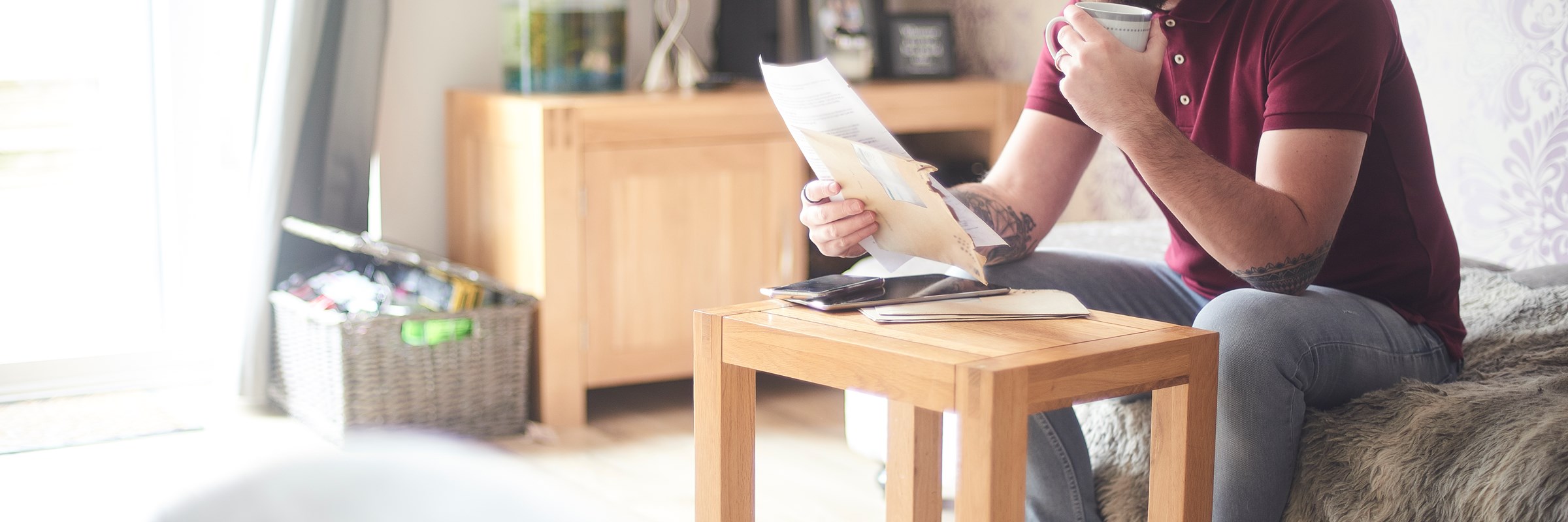 Man drinking a coffee and reading a bill