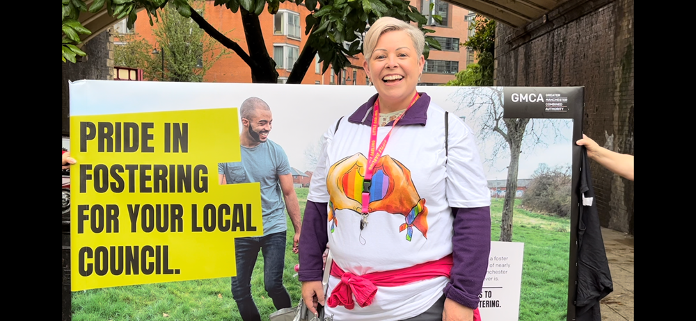 Picture of Pippa stood infront of a banner that says 'Pride in fostering for your local council'