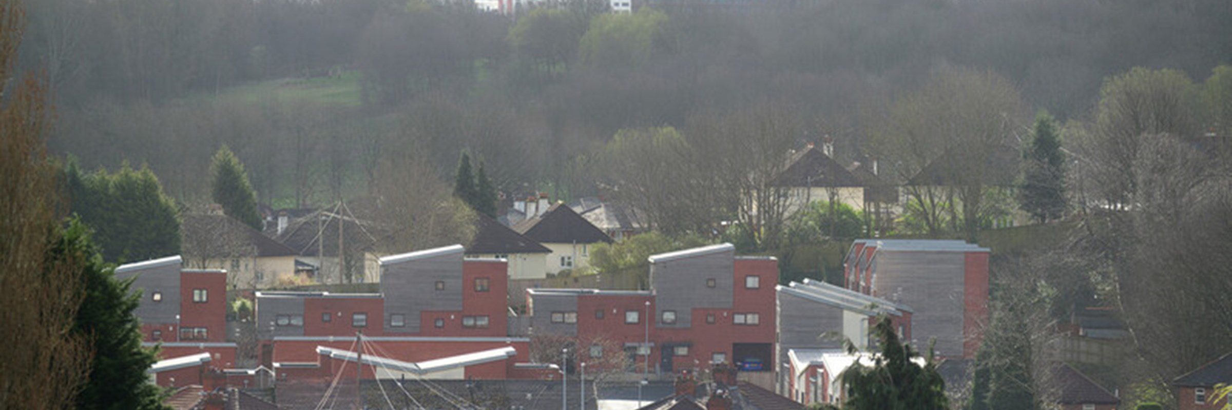 An image of houses with high rise housing in the background