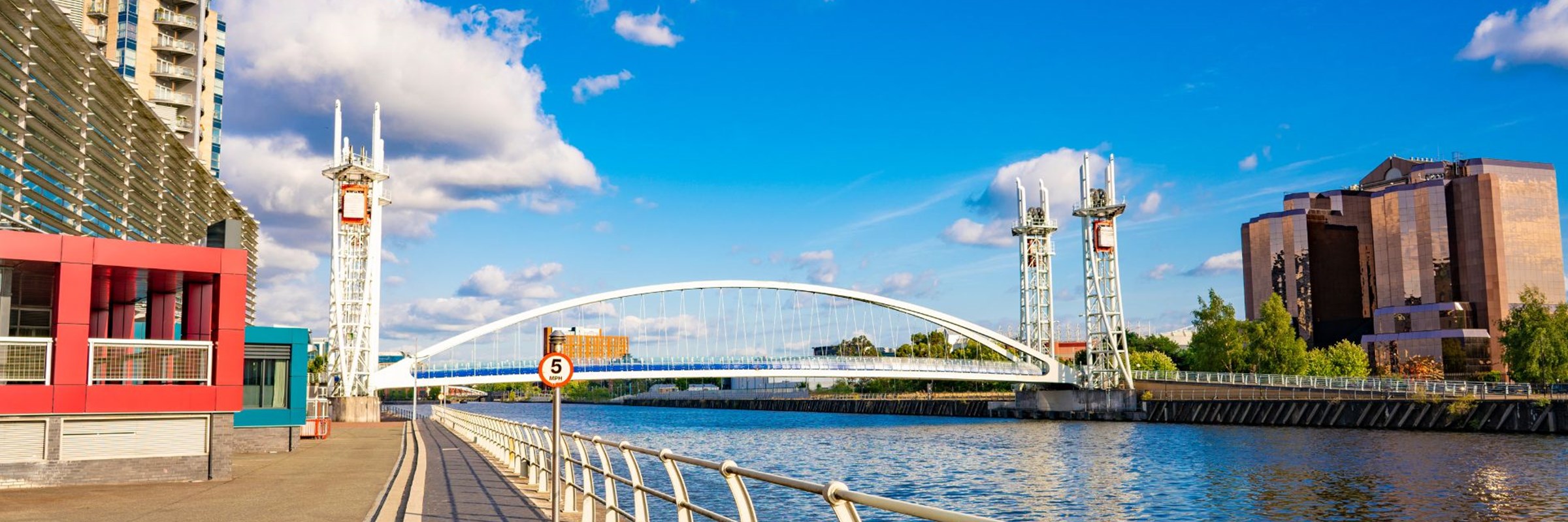 A bridge over a body of water with buildings in the background