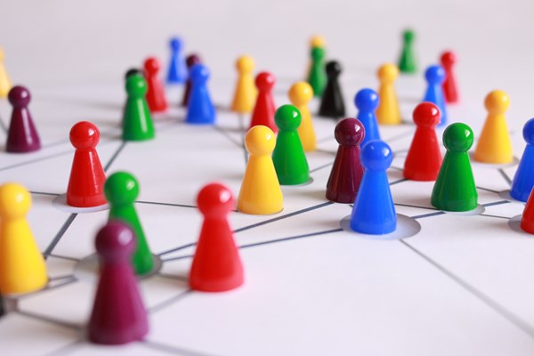 Image of board game plastic pieces grouped together on an image depicting a network