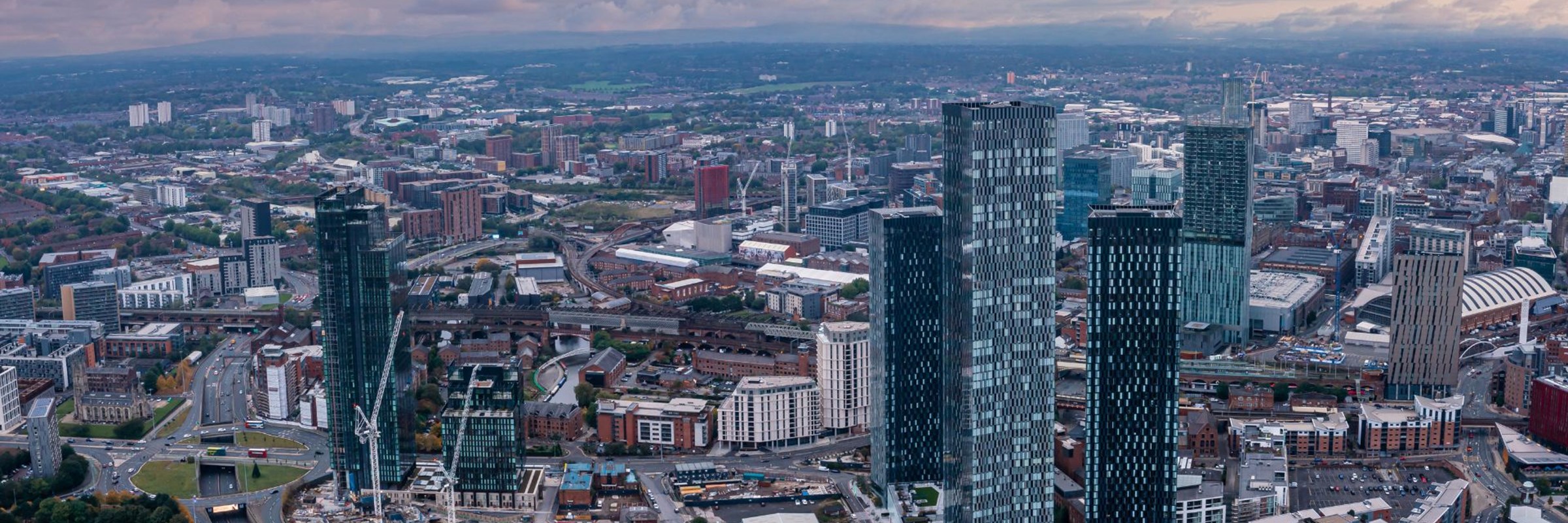 an aerial view of the city of Manchester at sunset.