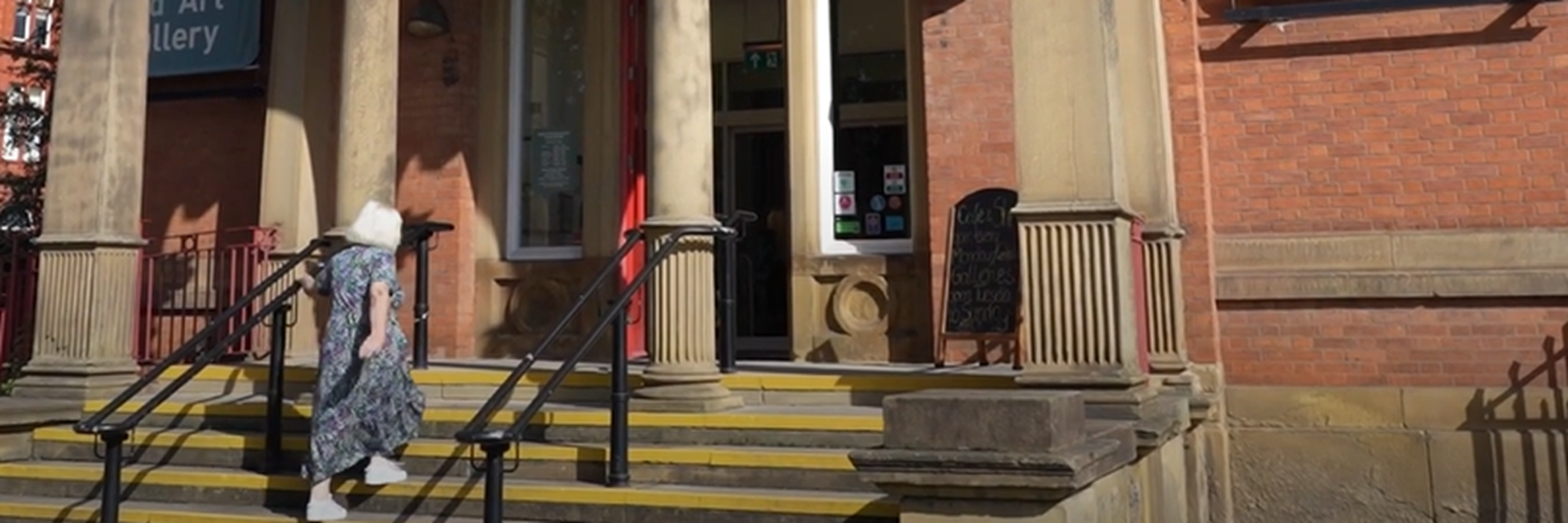 A person walking up the stairs of an old building.