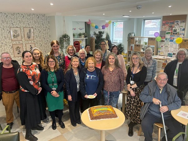 Group of people smiling at Age UK Stockport IDOP event
