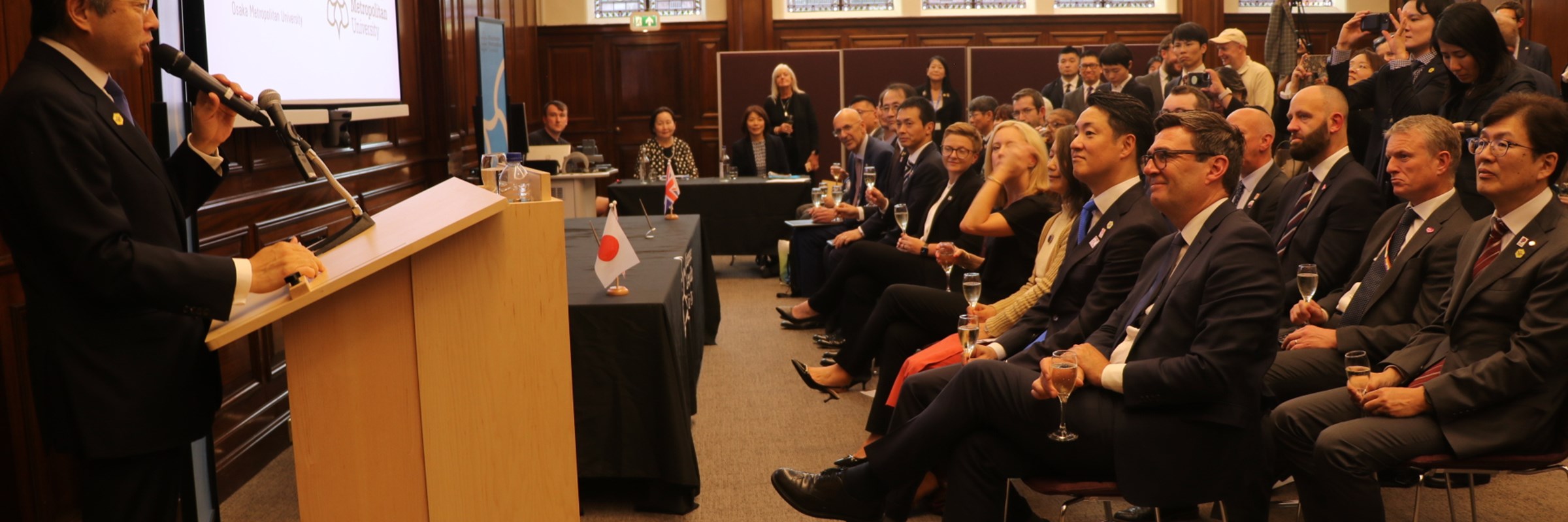 Ambassador Suzuki gives a speech from a lectern to a seated audience