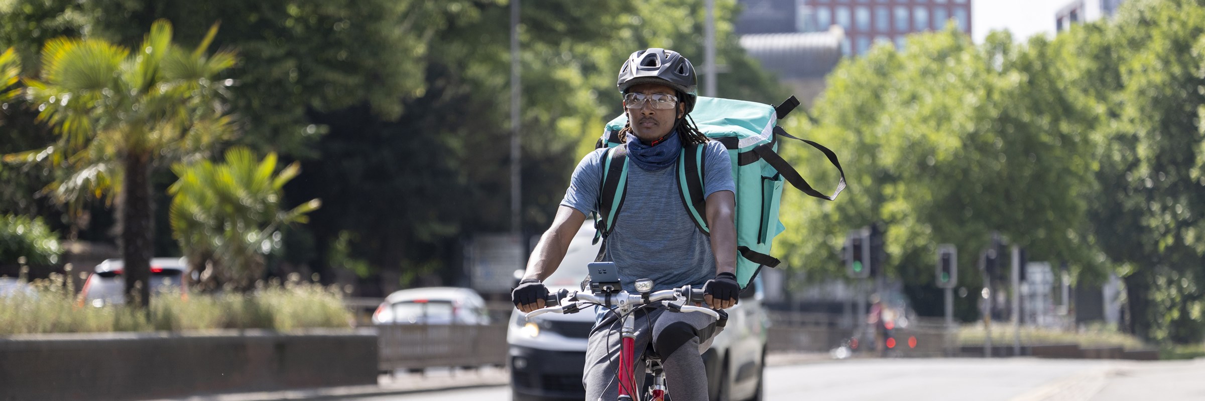 Courier on bike delivering takeaway food in city traffic