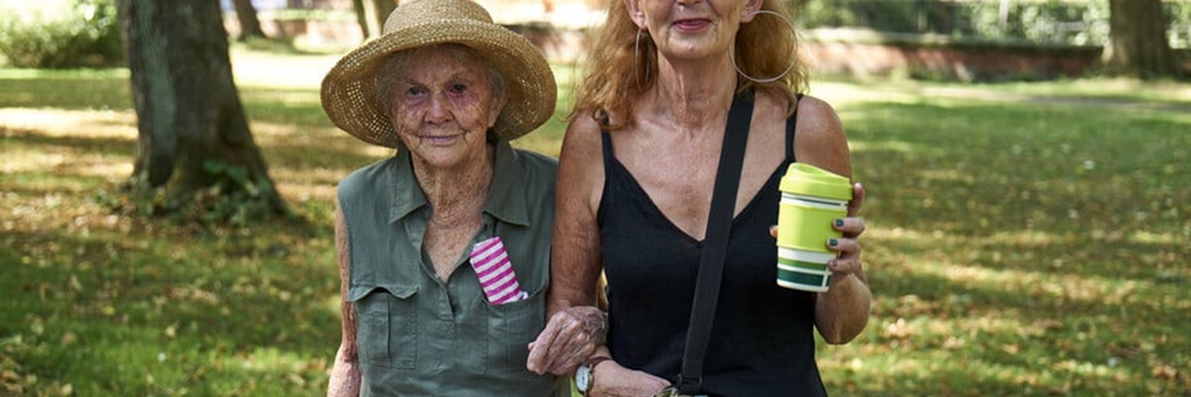 Two older women stood outside in the sun.