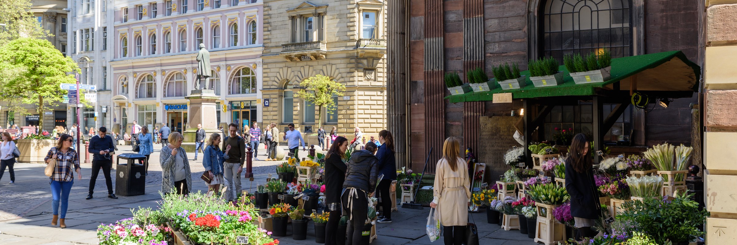 Exterior of florist shop in Manchester city centre, with people looking at flowers on display