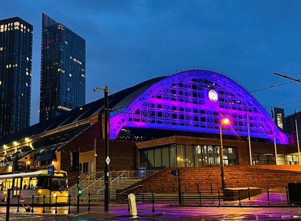 Manchester Central building lit up in purple
