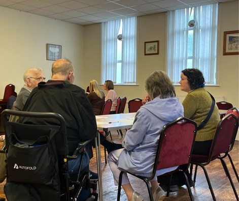 A group of people sat around a table talking.